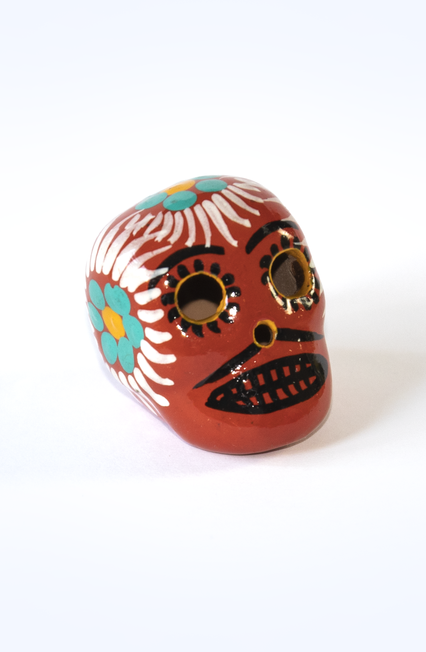 Teschio calavera rosso mattone con decorazioni floreali fatte a mano